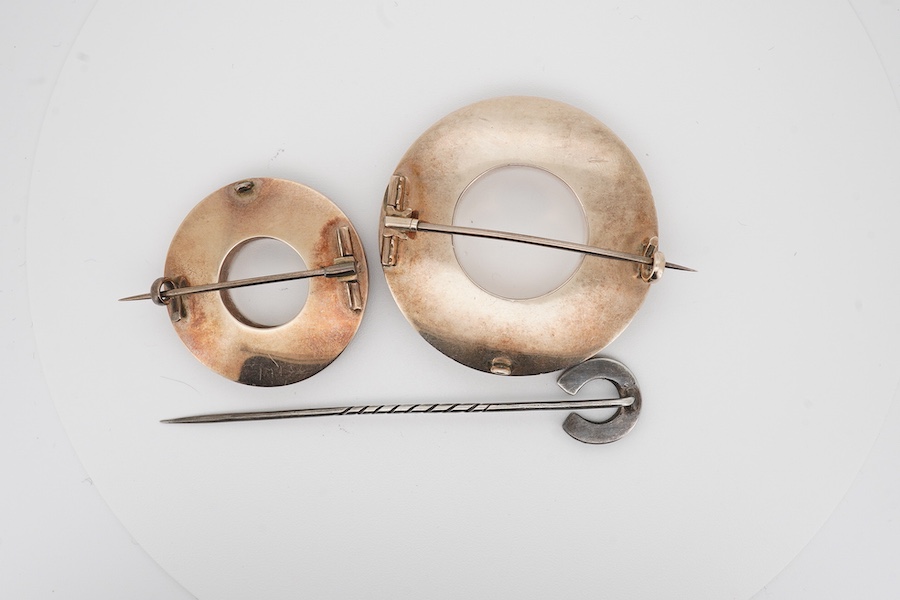 Two Scottish hardstone brooches and a stick pin, late 19th century, the brooches of annular design, the stick pin of horseshoe design, each inlaid with panels of jasper and bloodstone, largest brooch 4cm diameter, combin